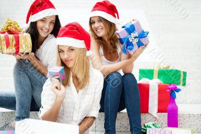 Group of three beautiful girls sitting on stairs at shopping mal