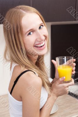 Portrait of beautiful relaxed young woman standing at the kitche
