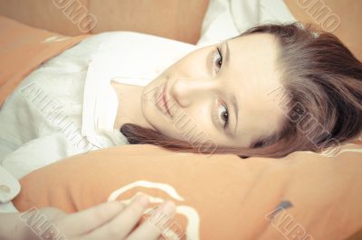 Closeup portrait of young pretty girl laying on her bed