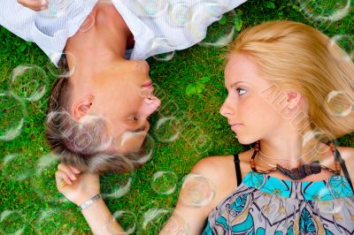 A portrait of a sweet couple in love with soap bubbles around. P