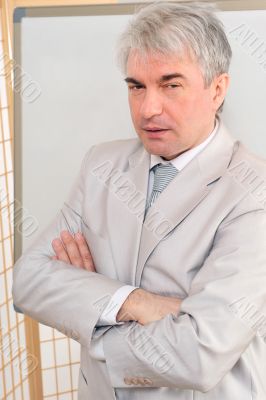 Closeup of a mature smiling business man standing in a light at 