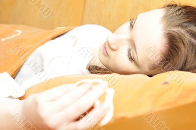 Closeup portrait of young pretty girl laying on her bed