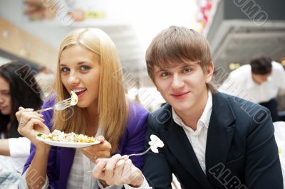 Closeup portrait of an attractive young couple eating fruit sala