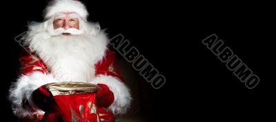 Santa sitting at the Christmas room and looking into the sack