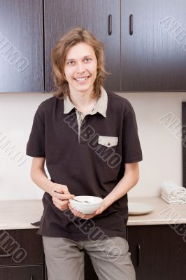 Happy young man after having a breakfast at home
