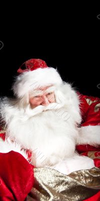 Santa sitting with a sack indoor at dark night room