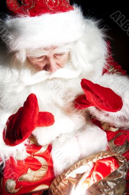 Santa sitting at the Christmas room and looking into the sack