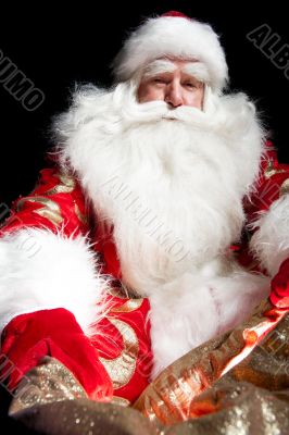 Santa sitting at the Christmas room and looking into the sack