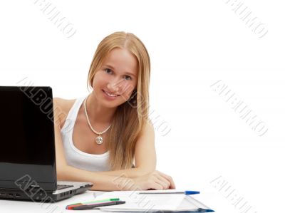 Portrait of a pretty female student with laptop and exercise boo