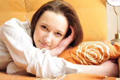 Closeup portrait of young pretty girl laying on her bed