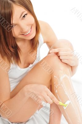 Cute woman shaving her legs