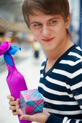 Portrait of young man inside shopping mall standing relaxed and 
