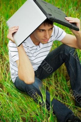A smiling man with laptop outdoor