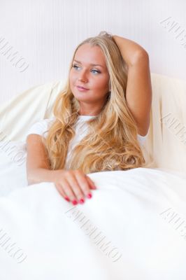Portrait Of Young Woman Relaxing On Bed
