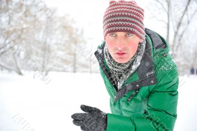 Closeup portrait of young man running in winter park