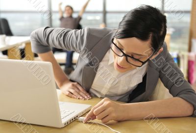 Portrait of a beautiful woman plugging a cord into her computer.