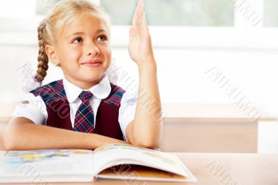 Image of smart child reading interesting book in classroom. Hori