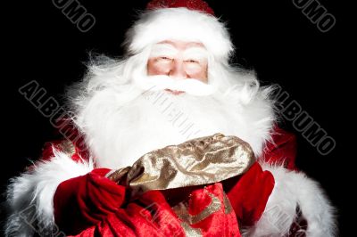 Santa sitting at the Christmas room and looking into the sack