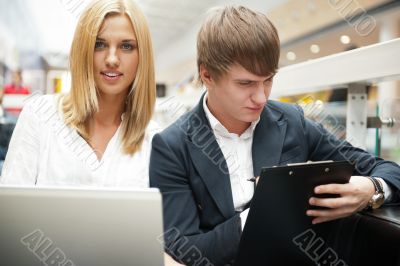 Two students working on their college project at hall using lapt