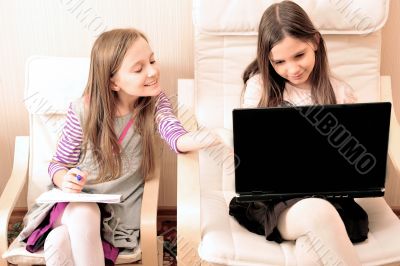Young girl doing she`s work on laptop sitting on armchair
