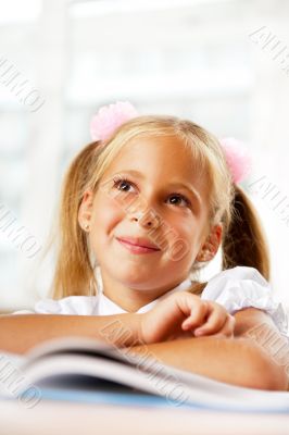 Portrait of a young girl in school at the desk.