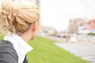 Cute young female sitting on grass and looking away - Outdoor in