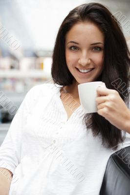 Closeup portrait of a pretty young female having a cup of coffee