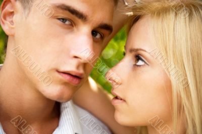 Portrait of beautiful young couple standing against green tree i