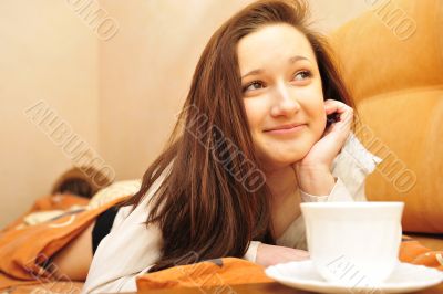 Closeup portrait of young pretty girl laying on her bed