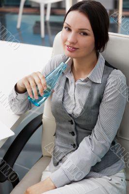 Beautiful business woman thinking about something while drinking