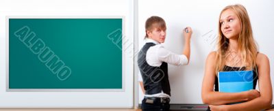 Two students - girl and boy making presentation at classroom