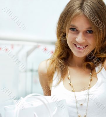Photo of young joyful woman with shopping bags on the background