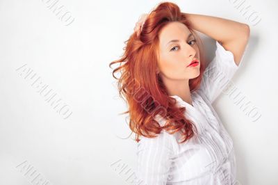 Young beautiful smiling woman standing against a wall and holdin