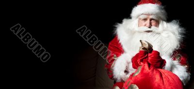 Santa sitting at the Christmas room and looking into the sack