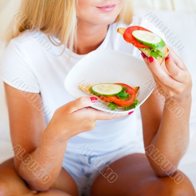 Woman having breakfast in bed. Healthy continental breakfast. Ca