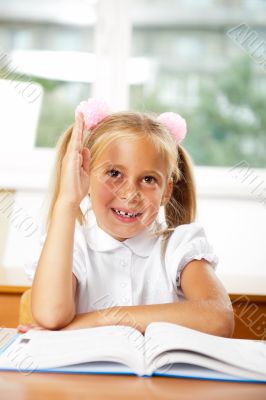 Portrait of a young girl in school at the desk.