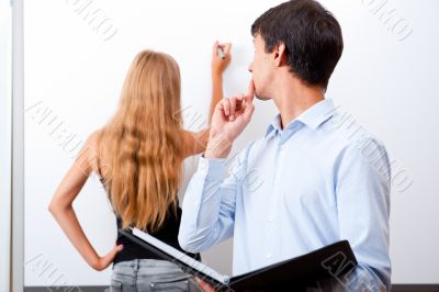 Closeup of adult teacher with student presenting her work on whi