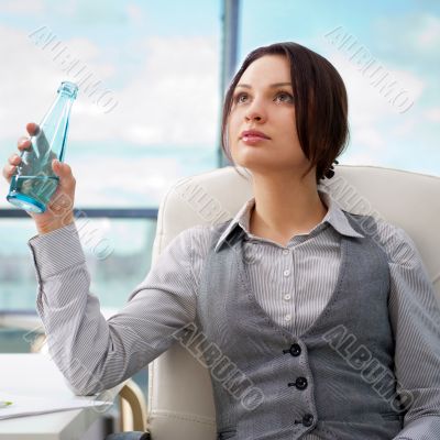 Beautiful business woman thinking about something while drinking