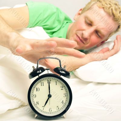 A man in his bed before waking up in his bedroom