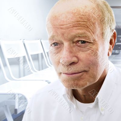 Portrait of a happy senior man smiling over bright background of