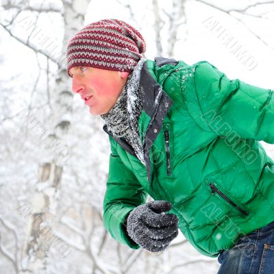 Closeup portrait of young man running in winter park