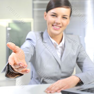 Business woman gives a handshake at her office