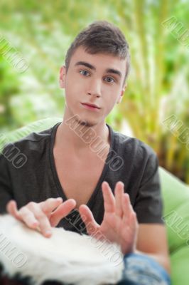Happy young handsome man at home against palm tree, smiling and 