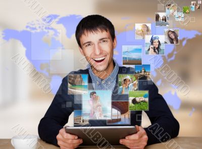 A technology man has images flying away from his modern tablet c