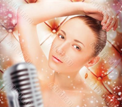 Portrait of a glamorous girl at stage singing and dancing