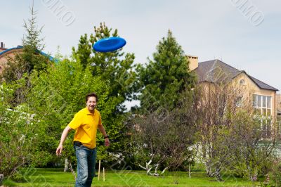 Man playing frisbee at his backyard