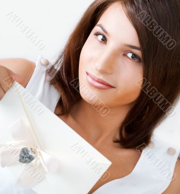 Delighted woman reading a greeting card sitting on the sofa at h