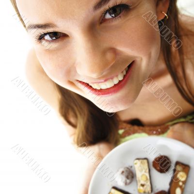 beautiful woman showing plate full of of chocolate candies in a 