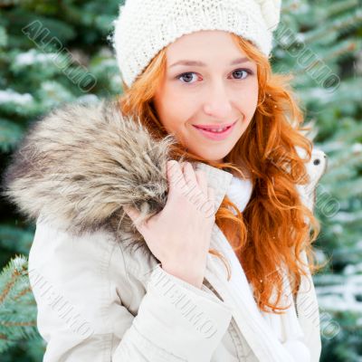 Portrait of young pretty woman in winter park 