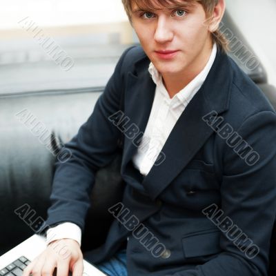 Portrait of handsome young man working with laptop at cafe at bu